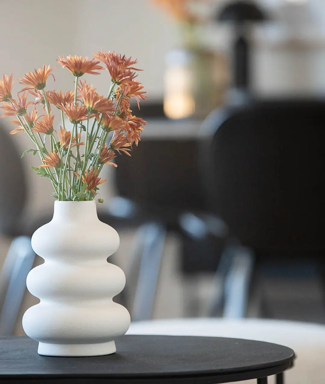 Vase blanc garni de fleurs orangées dans un condo Jardins Mirabel