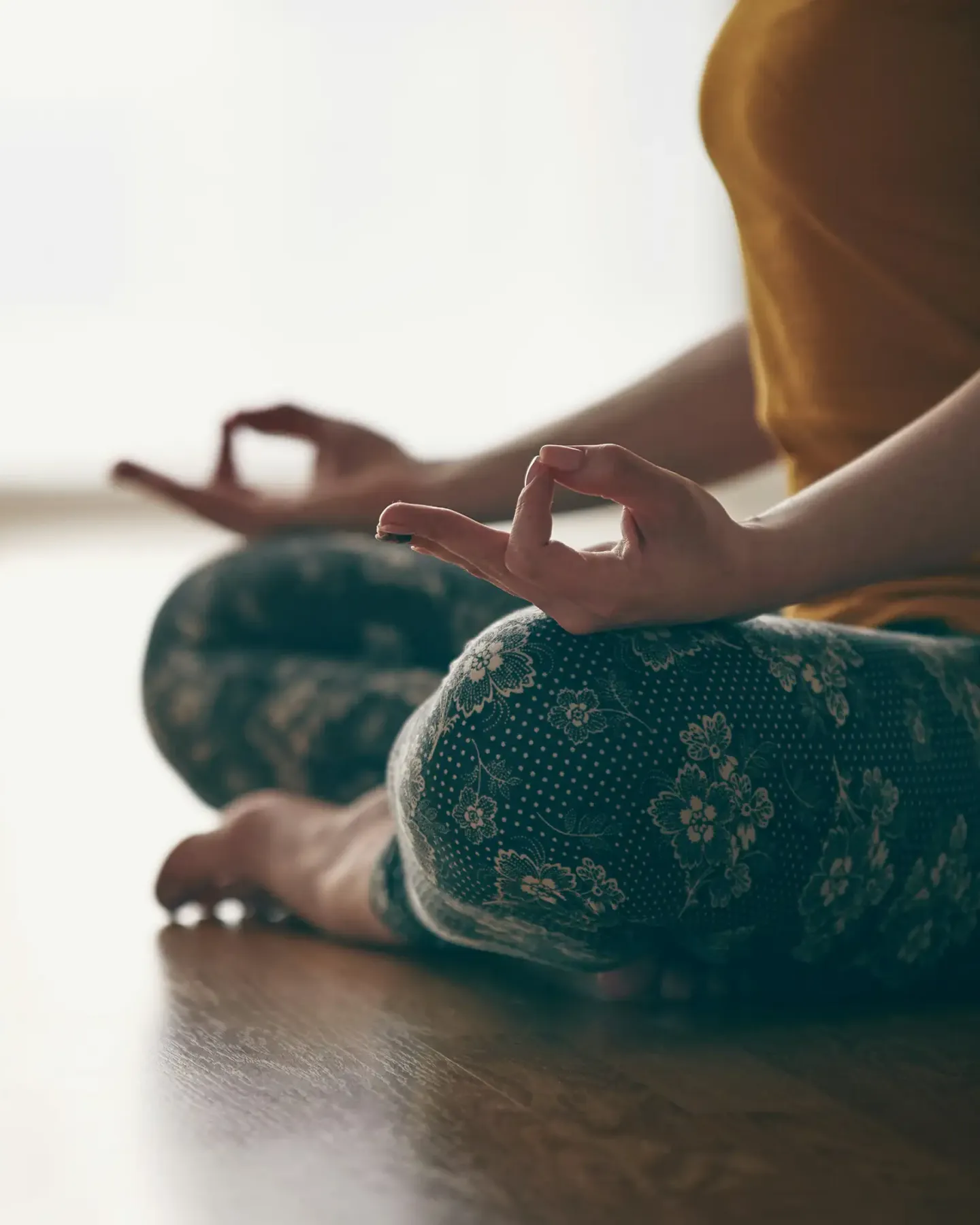 Personne assise en méditation dans un espace baigné de lumière naturelle